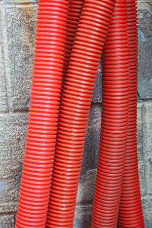 Red corrugated curvilinear tubes for construction close-upの写真素材