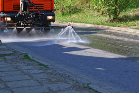 Cleaning car special vehicles spray water on asphalt road, close upの写真素材