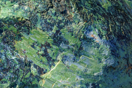 background, texture - rough surface of cliff from serpentinite, natural stone with a green tint