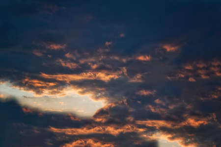 Sky blue and orange light of the sun through the clouds in the sky