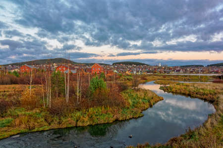 Beautiful autumn forest with colorful trees and pacturesque sky reflected in the water. Autumn nature landscape.の写真素材