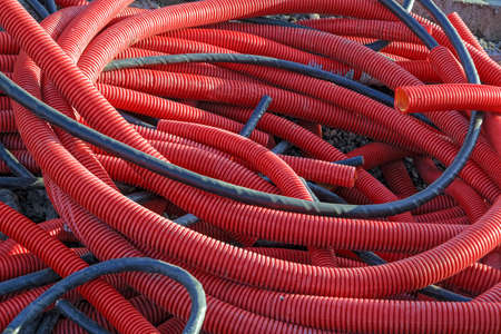 Red PVC corrugated pipes for cable lay on the construction siteの写真素材