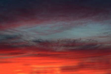 The sky with dark clouds illuminated by the setting sun