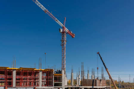 Construction of a mall cranes on a background of blue summer sky