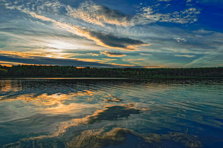 Autumn landscape sunset in the forest by the lake