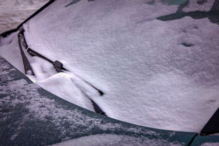 Frozen car windshield covered with ice and snow.の写真素材