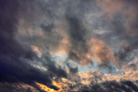 Sky blue and orange light of the sun through the clouds in the sky in the winter