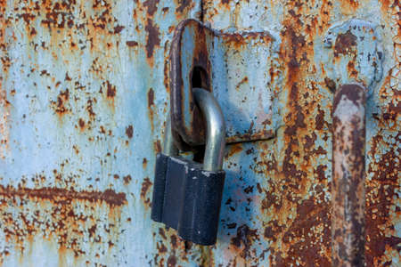 Closeup an ancient metal door locaked with a padlock. Grungy style and good texture.の写真素材