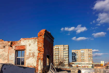 The ruins of a destroyed building in the city against the backdrop of a blue sky. Dual-ISO photo.の写真素材
