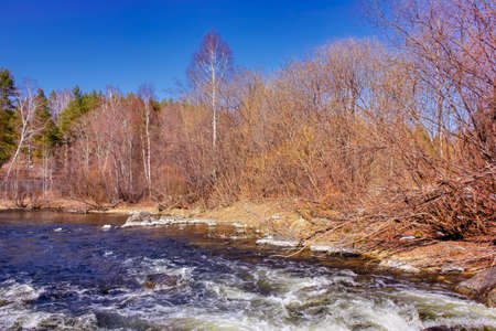 Spring landscape melts ice on a small river at the edge of the village.の写真素材