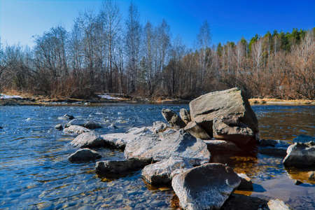 Spring landscape melts ice on a small river at the edge of the village.の写真素材