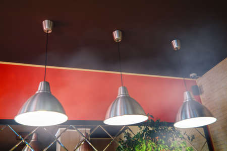 Lamp on the ceiling in cafe. The Ceiling lighting fixture in cafe interior.