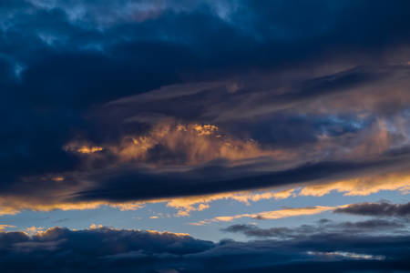 Dramatic evening sky with beautiful clouds illuminated by the setting sun.