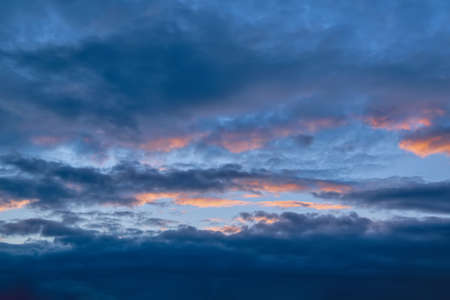 Dramatic evening sky with beautiful clouds illuminated by the setting sun.