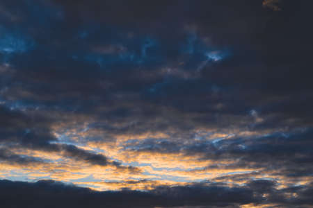 Dramatic evening sky with beautiful clouds illuminated by the setting sun.の写真素材