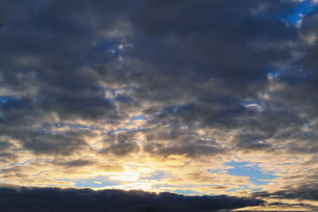 Dramatic evening sky with beautiful clouds illuminated by the setting sun.の写真素材
