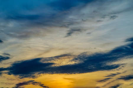 Dramatic evening sky with beautiful clouds illuminated by the setting sun.