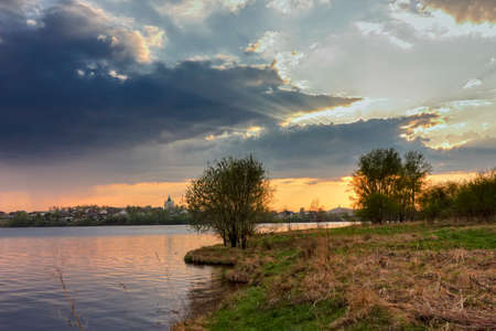 Dramatic sunset on the banks of the city pond.の写真素材