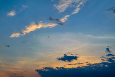 Dramatic evening sky with beautiful clouds illuminated by the setting sun.
