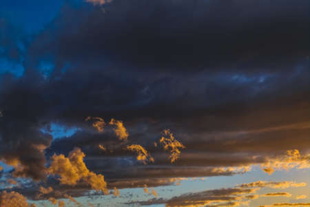 Sky blue and orange light of the sun through the clouds in the sky