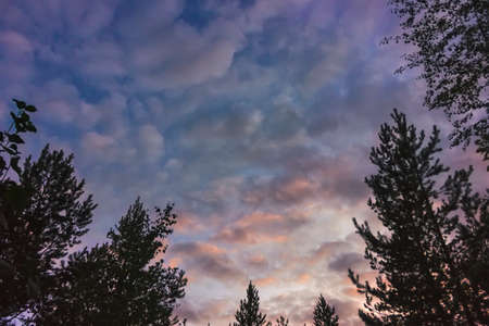 Cumulus sunset clouds with sun setting down. The sky with dark clouds illuminated by the setting sun.の写真素材