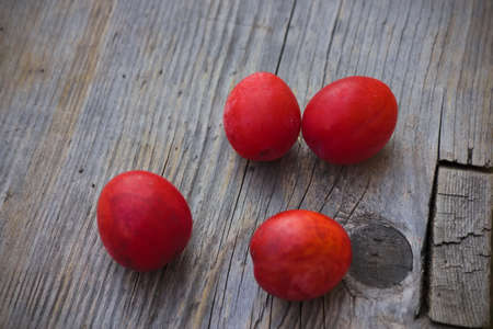 Ripe cherry plum fruits on a background of an old wooden table close-up.