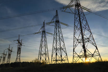 Electric lines at a substation against evening sky.