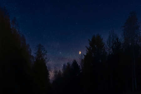 Beautiful romantic sunset, moon and bright stars in dark blue sky.の写真素材