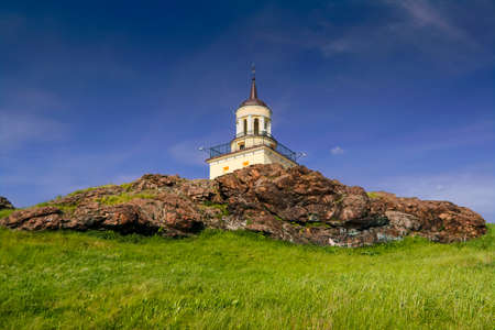 A chapel on top of a mountain against a blue summer sky and white clouds. Fox Mountain. Nizhny...