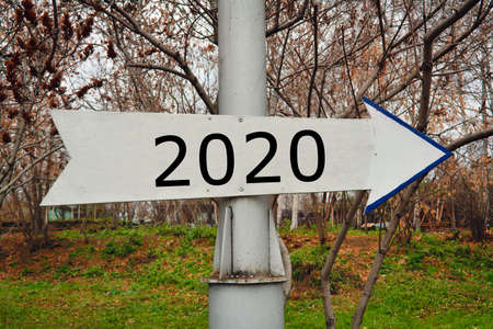 A white pointer on a post with the inscription 2020 in the autumn park. New Year concept.の写真素材