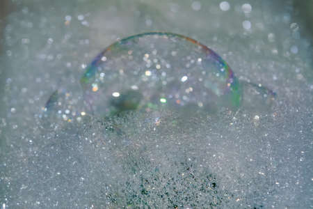 Texture of soapy foam with rainbow bubbles close-up. Soap foam on water surface.の写真素材