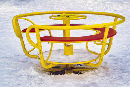Empty children's carousel in the park in winter close-up.の写真素材