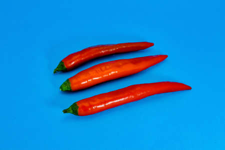 Close-up of red chili pepper against blue background.