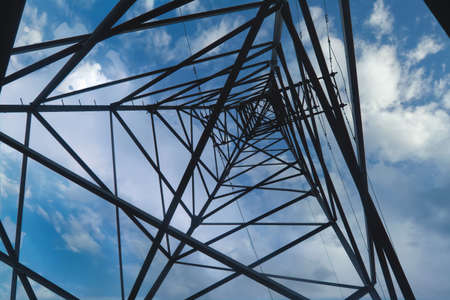 Abstract pattern from bottom view of high voltage pole power transmission tower with cloudy sky background.の写真素材