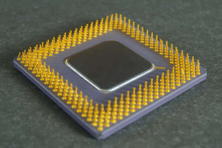 Processor microprocessor CPU of a computer lies on a dark matte surface. Close-up. Semiconductors, pins and connectors.の写真素材