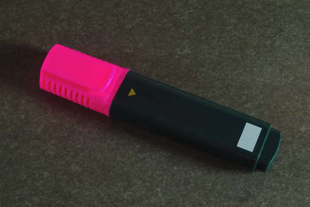 Pink wide stationery marker for highlighting text and drawing on dark gray background close-up.の写真素材