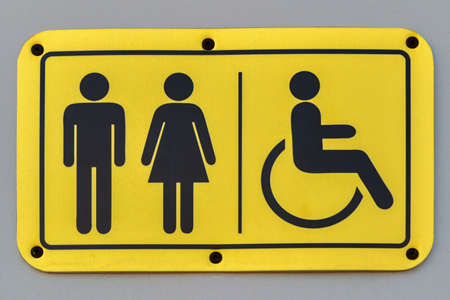 A plate with symbolic images of a man, woman and person in a wheelchair.の写真素材