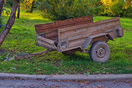 Car trailer. An old car trailer stands on the green lawn.