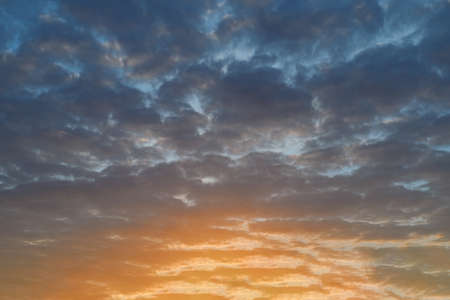 Summer evening sky in the picturesque clouds, lit by the rays of the setting sun.