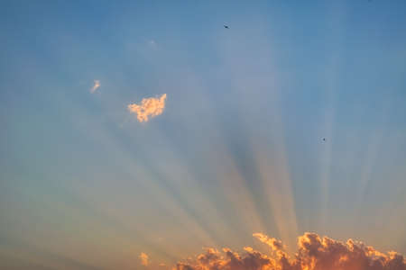 Evening sky in the picturesque clouds, lit by the rays of the setting sun.の写真素材