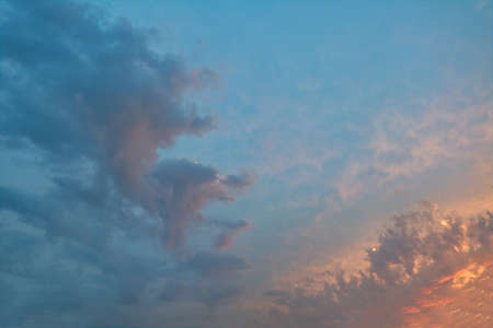 Evening sky in the picturesque clouds, lit by the rays of the setting sun.