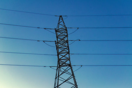 Mast of a high-voltage power line against the blue sky.の写真素材