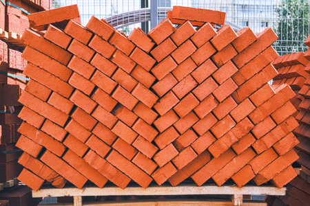 Stack of bricks close up. Process of house building and building materials concept. Red bricks for laying at construction site. Brick wallpaper pattern.の写真素材