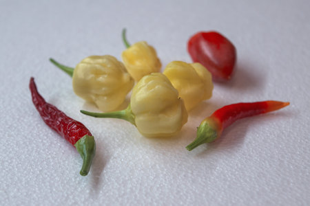 Different Yellow and red sharp peppers on a white background.