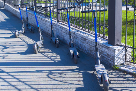 Electric scooters for rent standing in the park.の写真素材