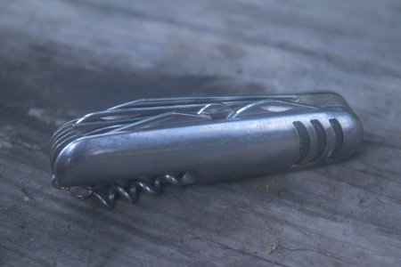 Multifunctional knife on the background of an old wooden table, close-up.の写真素材
