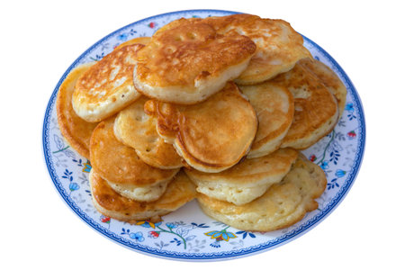 Plate with thick homemade pancakes on white background. Freshly baked homemade cakes.