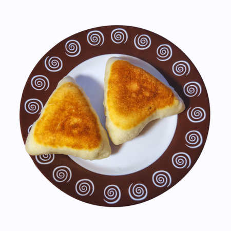 Triangular fried pies with chicken meat and onions on a platter on a white background.の写真素材
