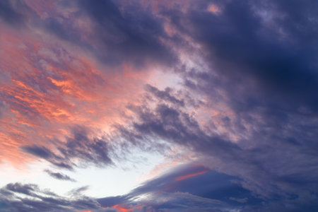 Evening sky in the picturesque clouds, lit by the rays of the setting sun.の写真素材