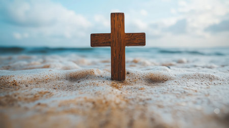 A wooden cross stands on a sandy beach with gentle waves, symbolizing faith and tranquility. The serene oceanfront setting under clear skies evokes a peaceful connection to nature.の素材